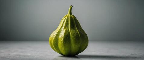A single whole starfruit presented on a light background, highlighting its unique shape and vibrant green color. photo