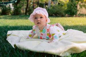 Beautiful baby girl lay in garden on the lawn photo