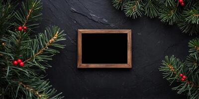 Festive Christmas frame placed on a black stone with a pine branch. photo