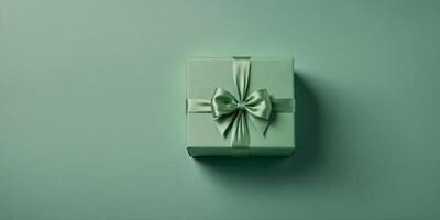 Light green present box with bow on the pastel green background, top view,. photo