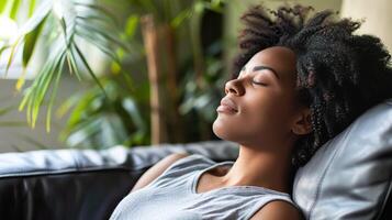 A woman enjoys a peaceful moment of relaxation on a couch. photo