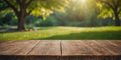 empty a wooden table top on green grass, blurred nature bokeh in sunlight, Spring background and ,for product display montage. photo