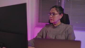 Close-up of young woman wearing glasses looking at large digital glitch screen while displaying lines of code. Professional hackers break into cyber security defenses. video