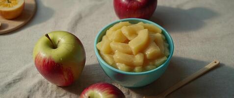 Apple puree in a bowl and toy plastic tableware Baby food concept Top View. photo