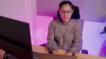 Woman building software and coding looks at large computer screen showing lines of programming language code. Female programmer working in monitor room futuristic concept video