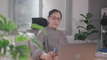 Woman sitting working at wooden table using laptop notebook looking at text typed on screen Happy woman chatting on computer, browsing the internet, social media, studying or working online at home video