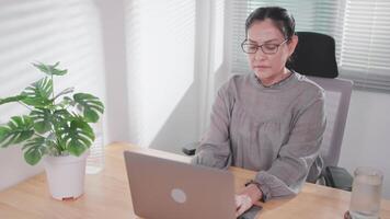 Asian woman working and using laptop at home or office Look at the computer screen, talk, read or write e-mail. video