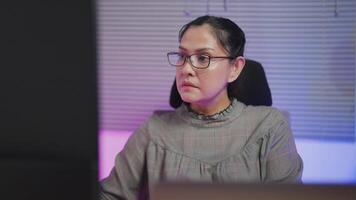 Close-up of young woman wearing glasses looking at large digital glitch screen while displaying lines of code. Professional hackers break into cyber security defenses. video