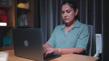 Businesswoman using laptop finishes work and turns off computer after work, hands on table and smiling with satisfaction after work in home office at nigh video