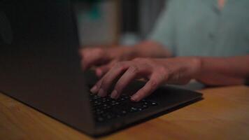 Close-up Asian woman typing on laptop keyboard at home working overtime at night Working by typing on a laptop for long periods of time Trying to work overtime until my hands hurt. Massage my aching video