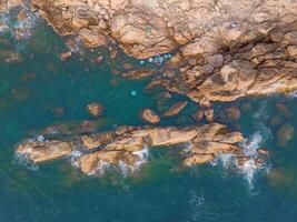 Aerial drone top view of beautiful waves crashing on the rocky island coast, ocean waves and fantastic. Ocean in Vietnam. photo