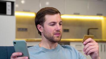 A man using credit card to make online payment on smartphone. Caucasian man using cellphone for shopping online. Guy using smart phone to check credit card transactions from app video