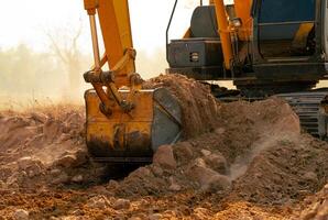 Backhoe working by digging soil at construction site. Crawler excavator digging on demolition site. Excavating machine. Earth moving machine. Excavation vehicle. Construction business. photo