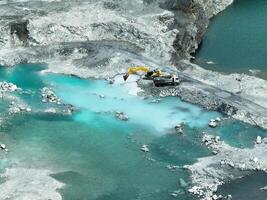Open pit mine industry. Limestone quarry with backhoe and truck in operation. Heavy machinery in mining industry and construction material supply. Landscape of resource extraction in a industrial site photo