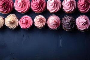 A row of colorful cupcakes arranged on a dark blue surface creating a festive and tempting display photo