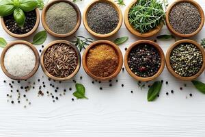An assortment of colorful spices and dried herbs in wooden bowls on a whitewashed wooden background photo