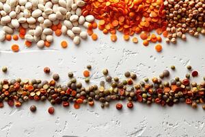 Colorful arrangement of various dried beans and lentils on a white concrete background photo