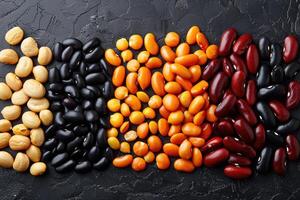 Various colorful dried beans and lentils on a dark background photo