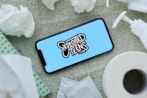 KYIV, UKRAINE - JANUARY 23, 2024 ExploitedTeens adult content website logo on display of iPhone 12 Pro photo