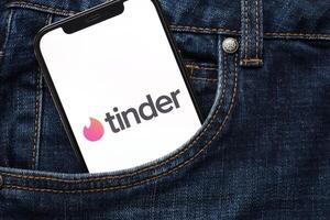 KYIV, UKRAINE - FEBRUARY 23, 2024 Tinder logo of famous dating website or app on iPhone display photo