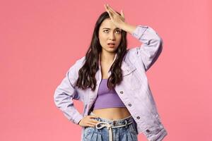 Portrait of sick and tired, annoyed young stylish girl taking care of new employee, facepalm, do eye roll and punch forehead sighing bothered, have lots of troubles, stand pink background photo