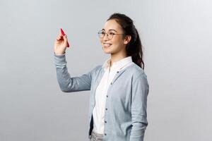 Teaching, online education and lifestyle concept. Young smiling smart student, tutor explain lesson material, solving exercise over blackboard, writing with red marker in air photo
