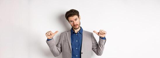 Confident man in business suit looking like professional, pointing at himself, self-promoting, standing on white background photo