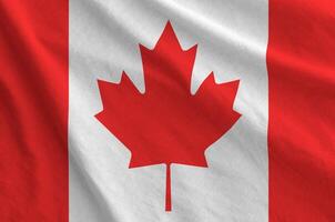 Canada flag depicted on folded wavy fabric of old cloth photo