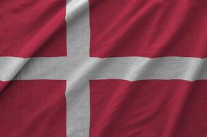Denmark flag depicted on folded wavy fabric of old cloth photo