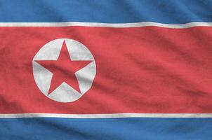 North Korea flag depicted on folded wavy fabric of old cloth photo