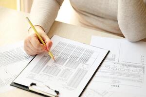 Female student hands testing in exercise and taking fill in exam paper sheet with pencil at school test photo
