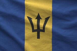 Barbados flag depicted on folded wavy fabric of old cloth photo