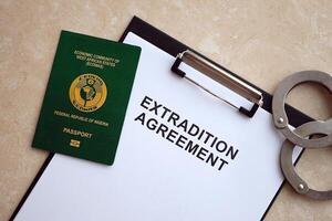 Passport of Pakistan and Extradition Agreement with handcuffs on table photo