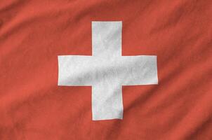 Switzerland flag depicted on folded wavy fabric of old cloth photo