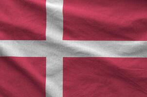 Denmark flag depicted on folded wavy fabric of old cloth photo