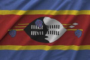 Swaziland flag depicted on folded wavy fabric of old cloth photo