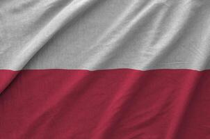 Poland flag depicted on folded wavy fabric of old cloth photo
