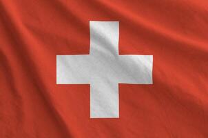 Switzerland flag depicted on folded wavy fabric of old cloth photo