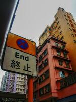 Chinese No Parking sign in Hong Kong with tall buildings, Vertical photo
