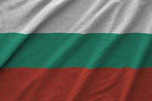 Bulgaria flag depicted on folded wavy fabric of old cloth photo