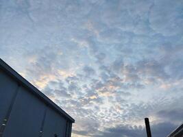 a view of the sky with clouds and a building photo