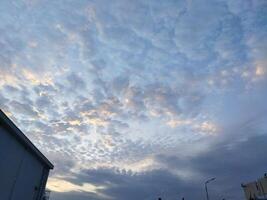 a view of the sky with clouds and a building photo