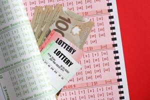 Lottery tickets lies with canadian dollars on gambling sheets with numbers for marking to play lottery photo