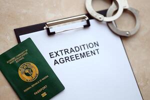 Passport of Pakistan and Extradition Agreement with handcuffs on table photo