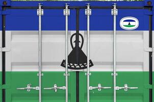Lesotho flag depicted on metal doors of shipping cargo container outdoors in docks area photo