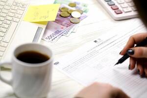 KYIV, UKRAINE - OCTOBER 31, 2023 Accountant fill french tax form 2041E Withholding tax declaration in end of tax period. Taxation and paperwork routine photo