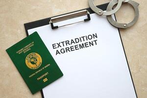 Passport of Pakistan and Extradition Agreement with handcuffs on table photo