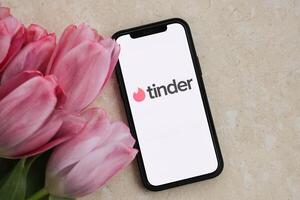 KYIV, UKRAINE - FEBRUARY 23, 2024 Tinder logo of famous dating website or app on iPhone display photo