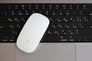 KYIV, UKRAINE - NOVEMBER 27, 2023 Apple Magic Mouse 3rd generation lies with grey MacBook 2021 photo