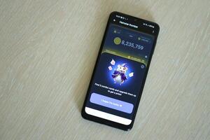 KYIV, UKRAINE - APRIL 20, 2024 Hamster Kombat telegram bot on smartphone screen. Hamster Kombat is a viral Telegram crypto game for earn HMSTR tokens by managing virtual crypto exchange photo